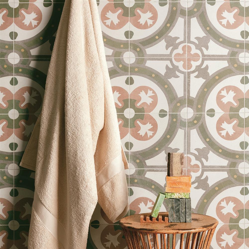 Mediterranean patterned bathroom tiles with a towel and small table